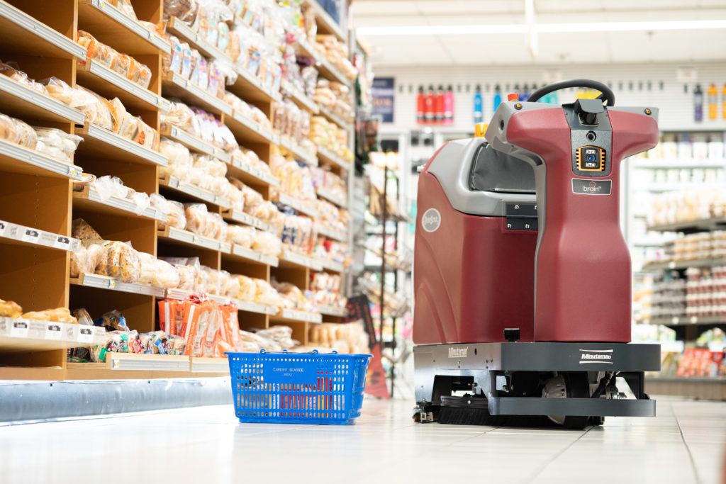 Minuteman's RoboScrub 20 scrubbing the floor around a hand basket in a grocery store